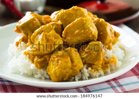 Chicken curry with rice white plate on wooden table