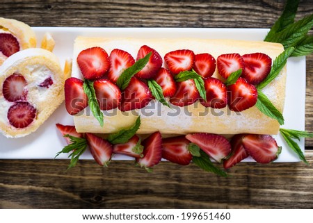 Homemade swiss roll biscuit cake with strawberries viewed from above