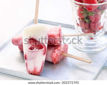 Strawberry yoghurt ice cream on a tray  on a white table