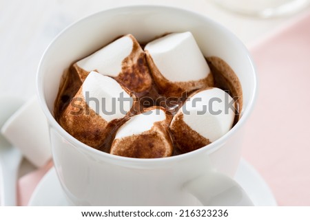 Cup of hot chocolate  with marshmallow on a white table. Warming drink for fall and winter