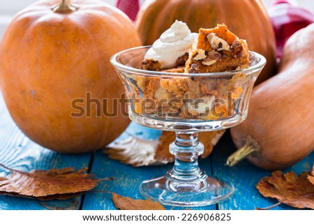 Pumpkin bread pudding topped with whipped cream, bread based pumpkin holiday dessert