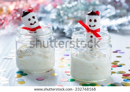 Delicious Christmas treat for dessert, cheesecake cream topped  with  sweet marshmallow snowman, served in a pretty jar