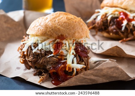 Pulled pork sandwich with cabbage slaw on top served on paper