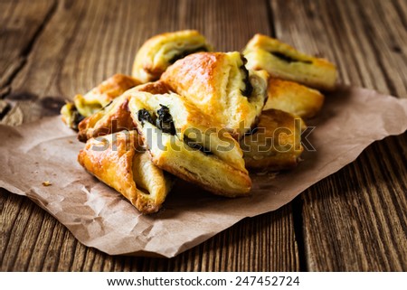 Spinach and cheese puff pastries triangles on paper
