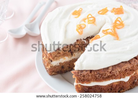 Mother\'s day carrot cake, homemade moist and sweet layer cake with grated carrot,  walnuts and dried apricot topped with swirls cream cheese frosting.  Delicious delight for holiday, pastel tones