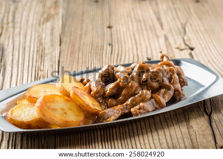 Beef Stroganoff,  original recipe of russian dish. Thin strips of beef  cooked in sour cream and tomato paste,  served with crisp potato