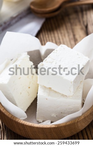 Organic dairy products on rustic wooden table. Farmer cheese in wooden bowl