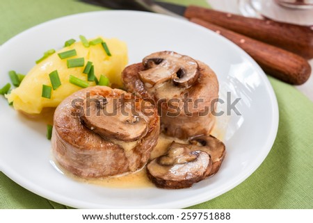 Homemade pork loin fillet with mashed potatoes and mushroom sauce on white plate