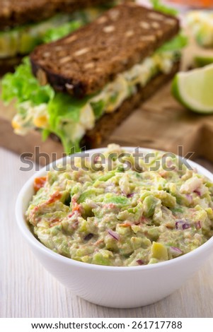 Healthy homemade guacamole, dip with  avocado, lime juice,  tomato, onion, and cream cheese
