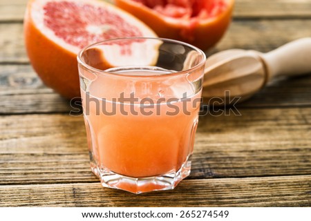Glass of fresh organic pink grapefruit juice ready to drink