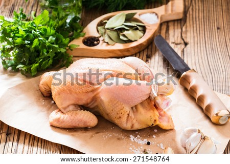 Raw chicken on wooden background, organic food, diet or cooking concept