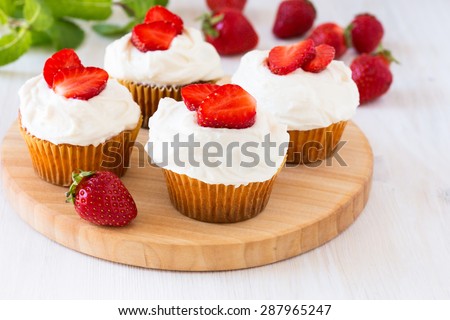Homemade strawberry cupcakes with whipped cream topping