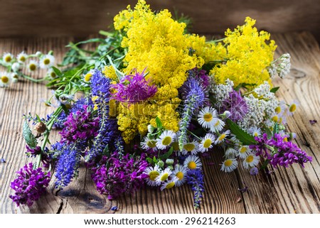 Summer meadow flowers bouquet on rural wooden background, concept fitoterapia, bioactive natural products of plant in pharmacotherapy