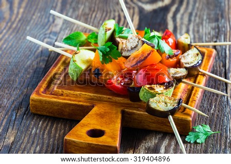 Fresh summer vegetable kebabs  with eggplant and cherry tomatoes, charred veggie skewers on cutting board, veggies eating concept
