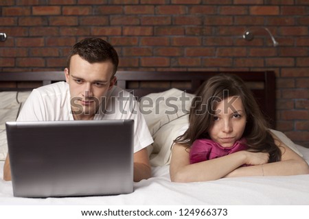 Man at computer, woman upset and angry
