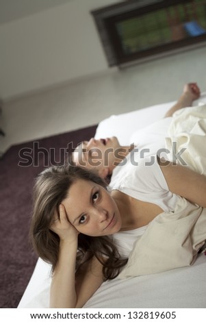 Man snoring on the bed and her wife can\'t sleep