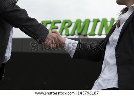 Closeup of businessmen shaking hands in front of a terminal
