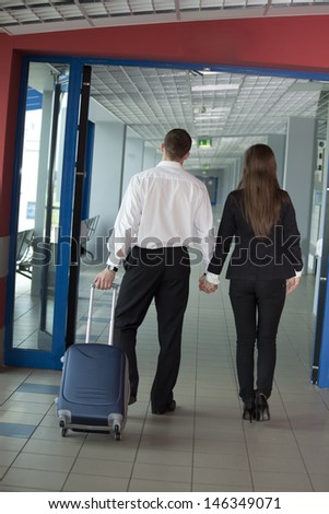 Two people walking with suitcase