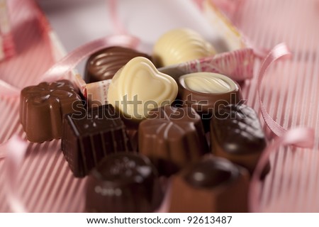 Chocolate heart close to chocolates in a box. Selective focus