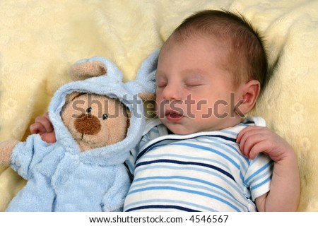 New born baby sleeping with toy stuffed animal