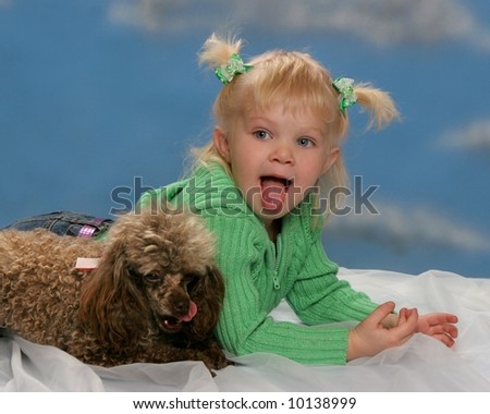 cute little girl with poodle, both sticking their tongues out