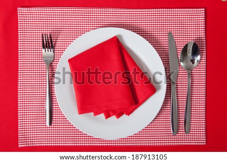 laid table/ fork and spoon laid on red cloth in the kitchen