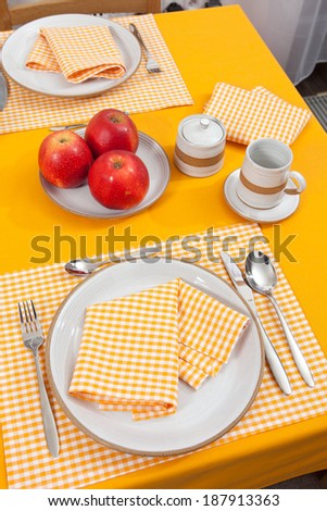 laid table/ fork and spoon laid on yellow cloth in the kitchen