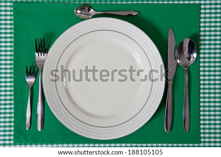 laid table/ fork and spoon laid on green cloth in the kitchen