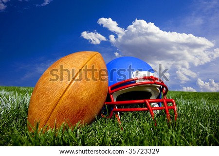 American Football and Helmet on a painted field with a bright blue background.