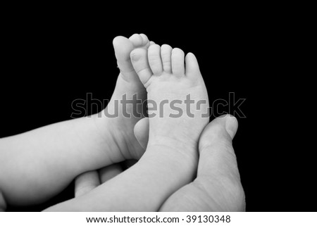 Tiny feet in dads hands.