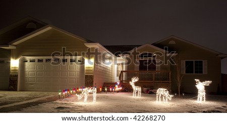 Home with Christmas Lights on a snowy night.