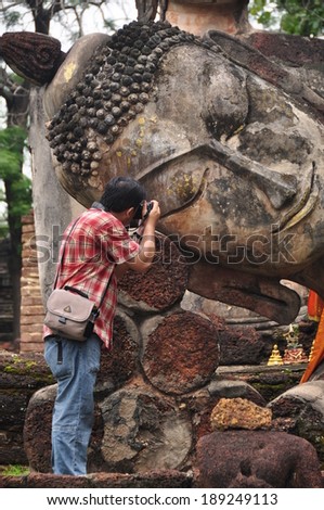 KAMPHAEPHET, THAILAND - JUNE 6 : Traveler take a photo Buddha image at Kamphaeng Phet Historical Park Aranyik area,Buddha of thailand on June 6, 2012 in Kamphaengphet Thailand