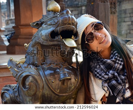 Thai woman portrait with Statue image Lion guarding at Bhaktapur Durbar Square  is the plaza in front of the royal palace of the old Bhaktapur Kingdom in Nepal