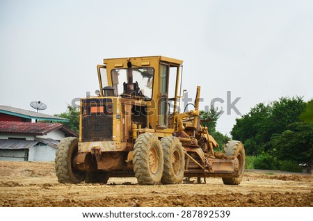 NONTHABURI, THAILAND - JUNE 12 : Motor grade machine and people working at construction site on June 12, 2015 in Nonthaburi, Thailand.