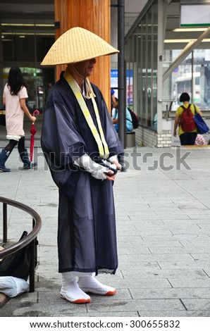 NARA, JAPAN - JULY 7 : Japanese monk standing at front of a small fountain near the kintetsu Nara station for receive donation from people on July 7, 2015 in Nara, Japan.