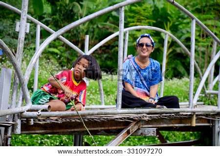 PHRAE, THAILAND - AUGUST 30 : Thai women portrait with children fishing on Bamboo bridge at Baan Natong village on August 30, 2015 in Phrae, Thailand