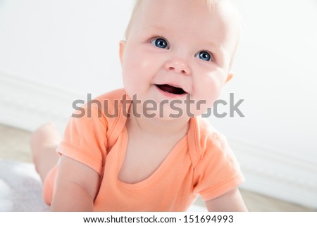 Cute baby girl with big blue eyes looking up, close up