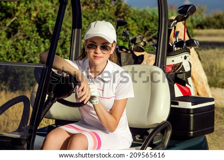 young female golf player on golf cart