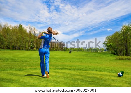 Woman golf player hitting by iron from fairway