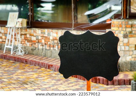 Curly black blank board on the building background and box for wedding congratulations