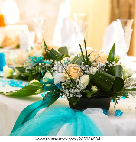 Bouquet of roses and turquoise ribbon on the wedding table