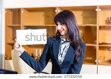 Beautiful woman with empty card in office