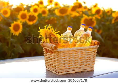 Three bottles of sunflower oil in a wicker basket against backlight