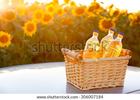 Three bottles of sunflower oil in a wicker basket in the sunset