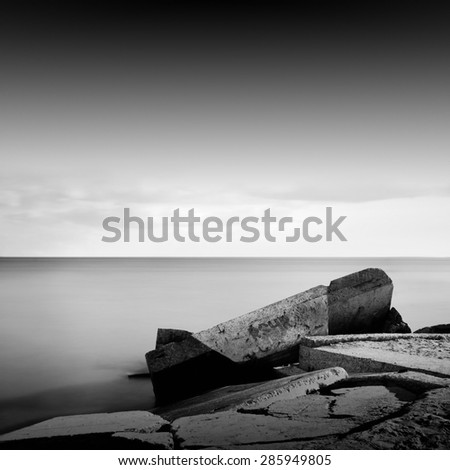 black & white daytime long exposure rocky seascape scene with stones and water. Black sea, Odessa, Ukraine