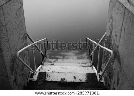 steps to nowhere. beautiful minimalist black and white seascape with stairs into the sea and milk water. shot taken in daytime \
with long exposure