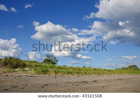 Clouds canvas the sky over a dune on a sea island in landscape orientation