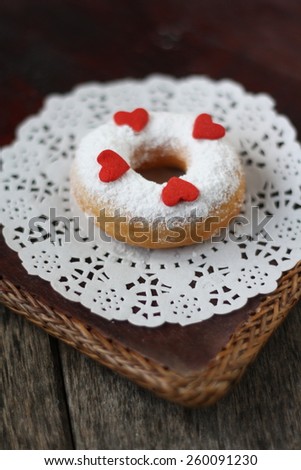 Doughnut with icing sugar and love shape sugar on top