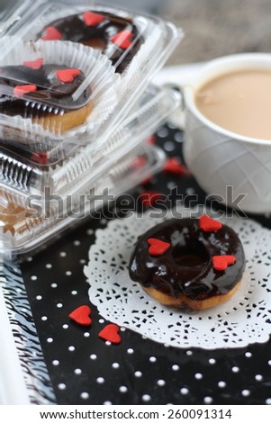 Doughnut with chocolate glazing and tea cream and in packaging