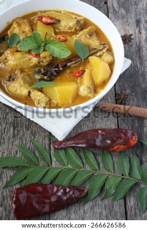 Kari Ayam - Malaysian Traditional cuisine. Spicy chicken curry with coconut milk garnished with curry and mint leaves